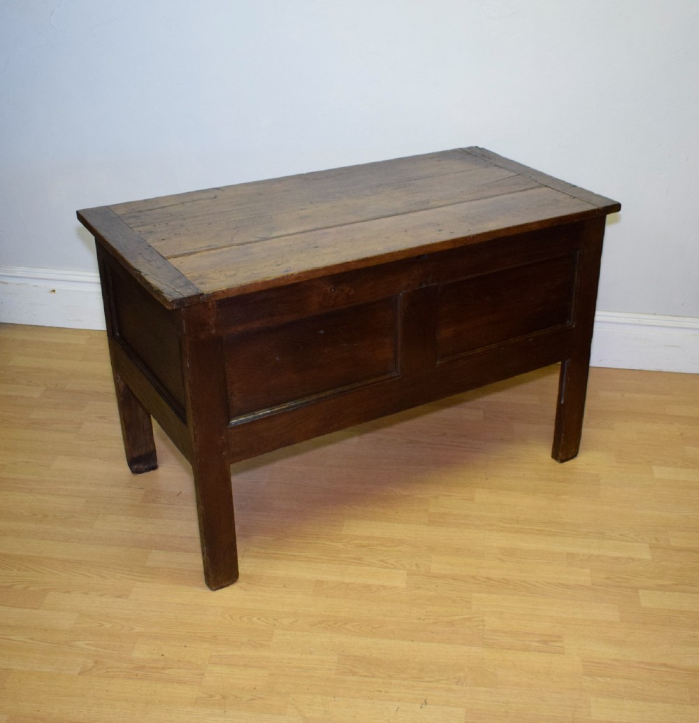 A dark oak seventeenth-century coffer featuring two plain rectangular front panels and a flat hinged top. View XIII
