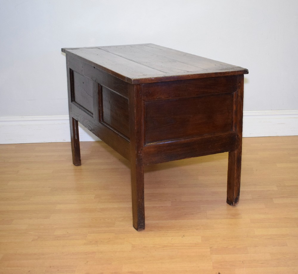 A dark oak seventeenth-century coffer featuring two plain rectangular front panels and a flat hinged top. View XIV