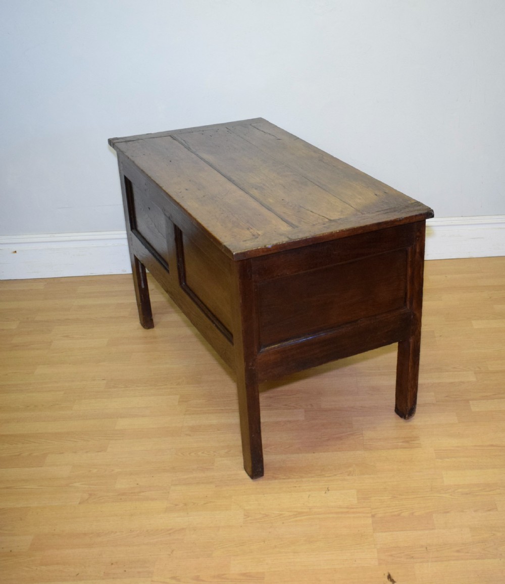A dark oak seventeenth-century coffer featuring two plain rectangular front panels and a flat hinged top. View XV