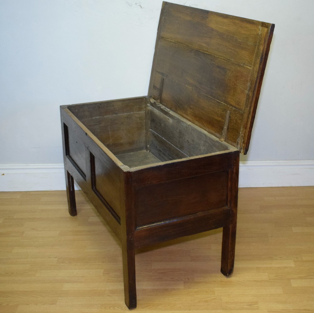 A dark oak seventeenth-century coffer featuring two plain rectangular front panels and a flat hinged top. View XVII