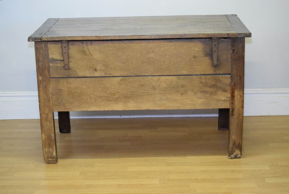 A dark oak seventeenth-century coffer featuring two plain rectangular front panels and a flat hinged top. View XIX