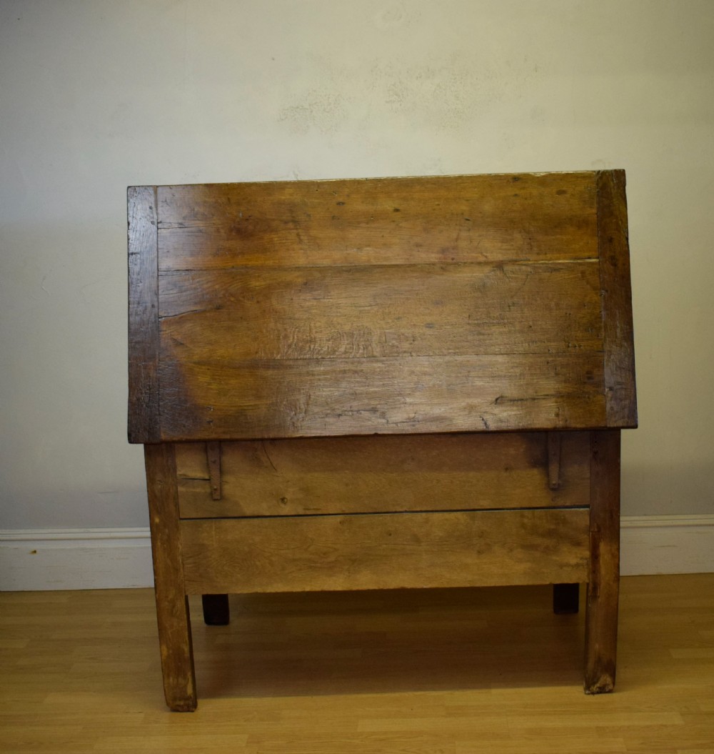 A dark oak seventeenth-century coffer featuring two plain rectangular front panels and a flat hinged top. View XX