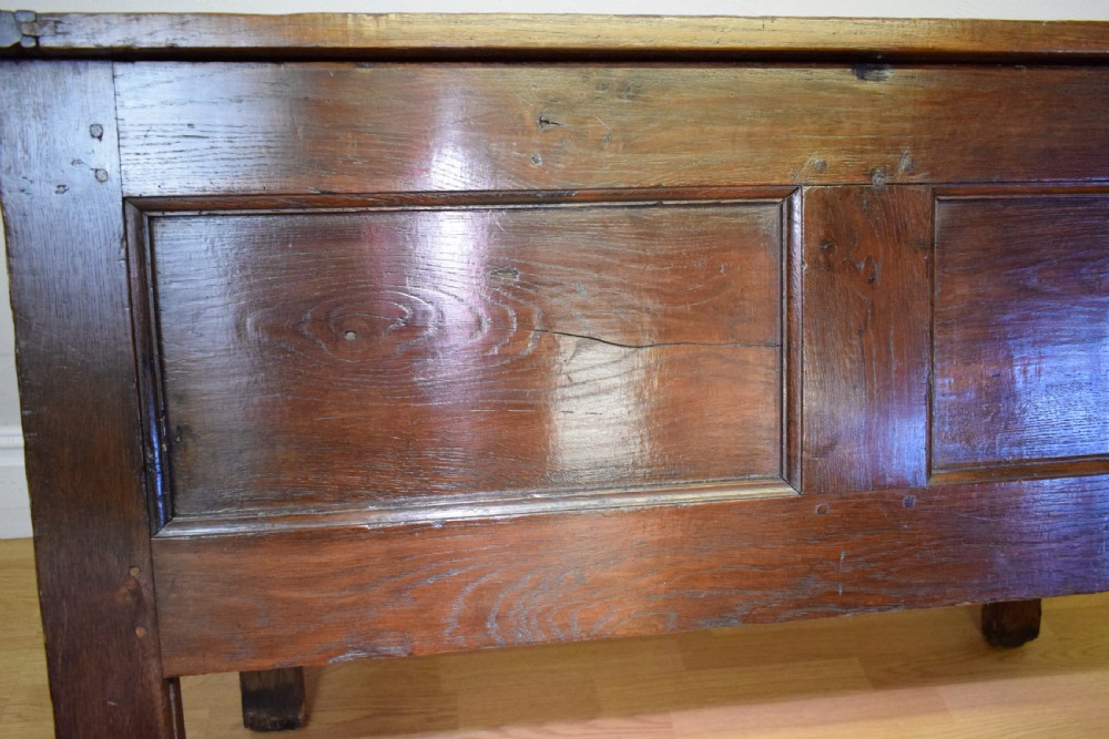 A dark oak seventeenth-century coffer featuring two plain rectangular front panels and a flat hinged top. View XXII