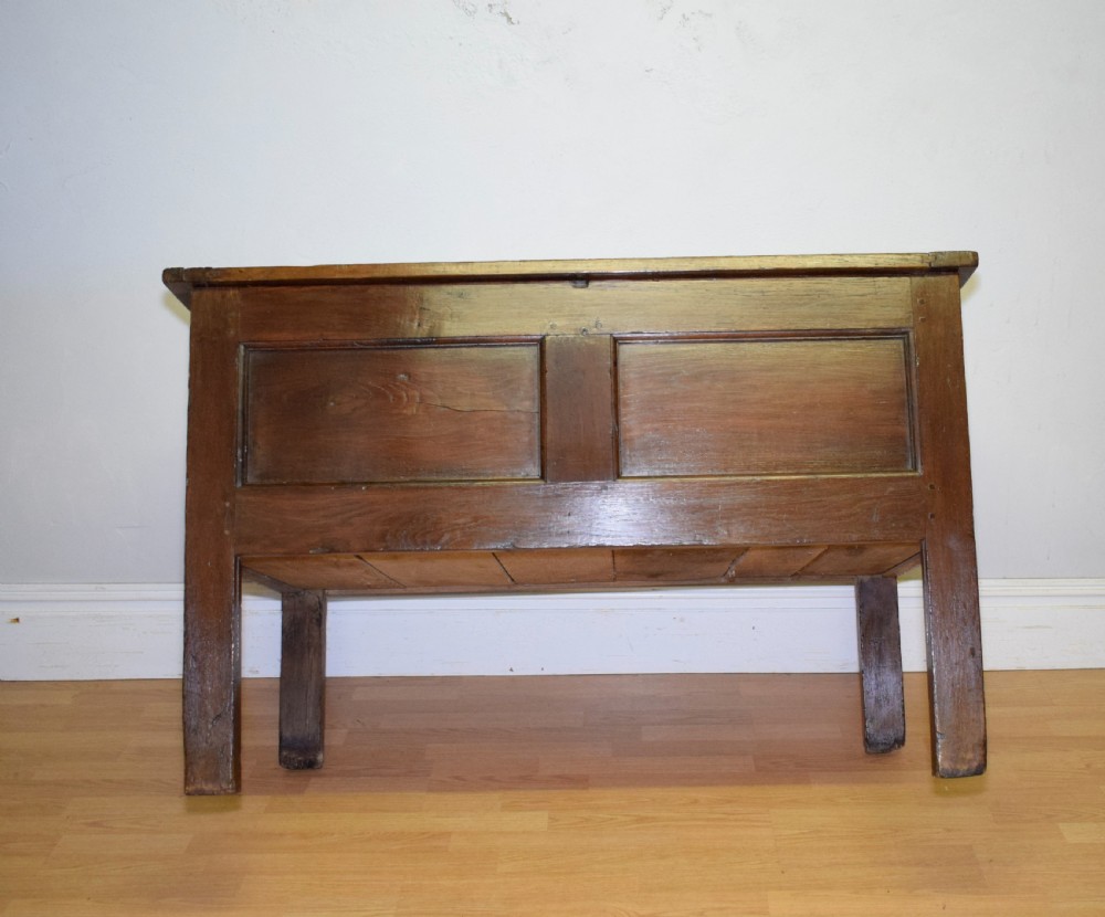 A dark oak seventeenth-century coffer featuring two plain rectangular front panels and a flat hinged top. View XXVI