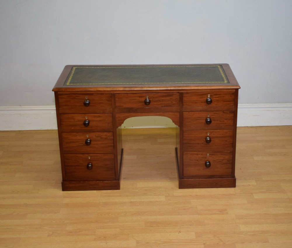 A Victorian mahogany pedestal desk with nine drawers, turned wooden handles, a dark leather insert top, and a central kneehole. View III
