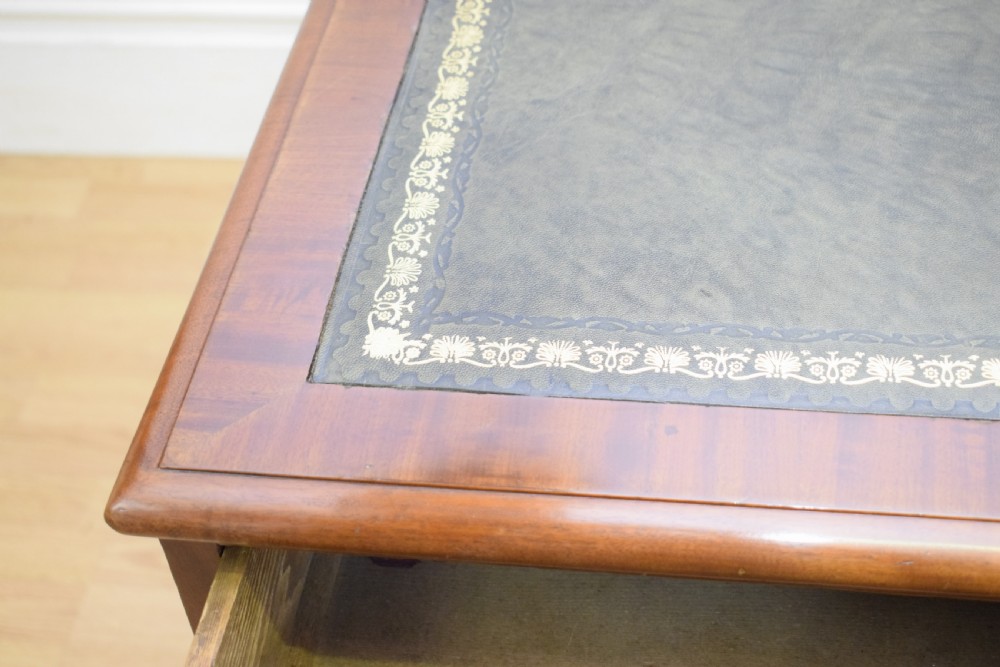 A Victorian mahogany pedestal desk with nine drawers, turned wooden handles, a dark leather insert top, and a central kneehole. View VI