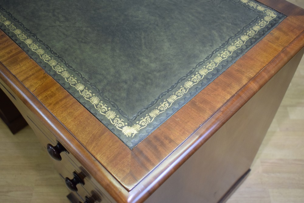 A Victorian mahogany pedestal desk with nine drawers, turned wooden handles, a dark leather insert top, and a central kneehole. View XII