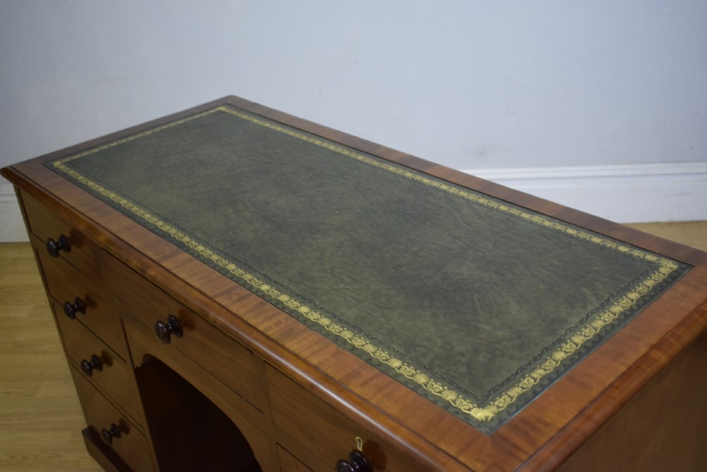 A Victorian mahogany pedestal desk with nine drawers, turned wooden handles, a dark leather insert top, and a central kneehole. View XIII
