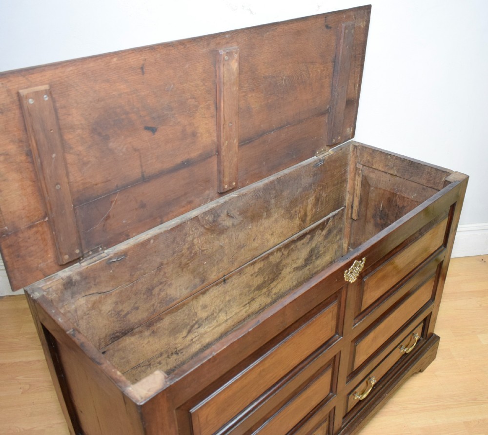 A Georgian dark oak Lancashire mule chest featuring a hinged top lid, panelled front sections with inlays, brass swan-neck handles, and bracket feet. View IX