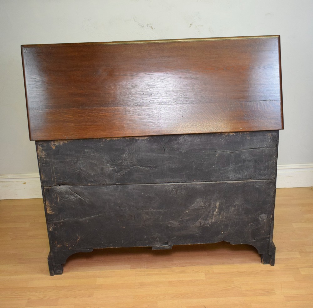 A Georgian dark oak Lancashire mule chest featuring a hinged top lid, panelled front sections with inlays, brass swan-neck handles, and bracket feet. View XIII