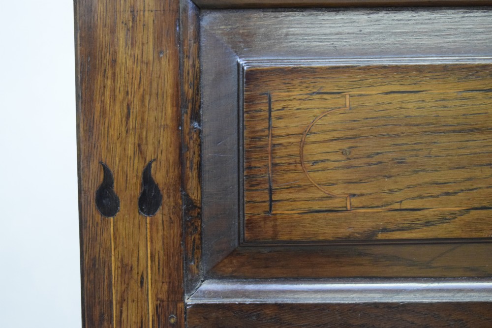 A Georgian dark oak Lancashire mule chest featuring a hinged top lid, panelled front sections with inlays, brass swan-neck handles, and bracket feet. View XIX