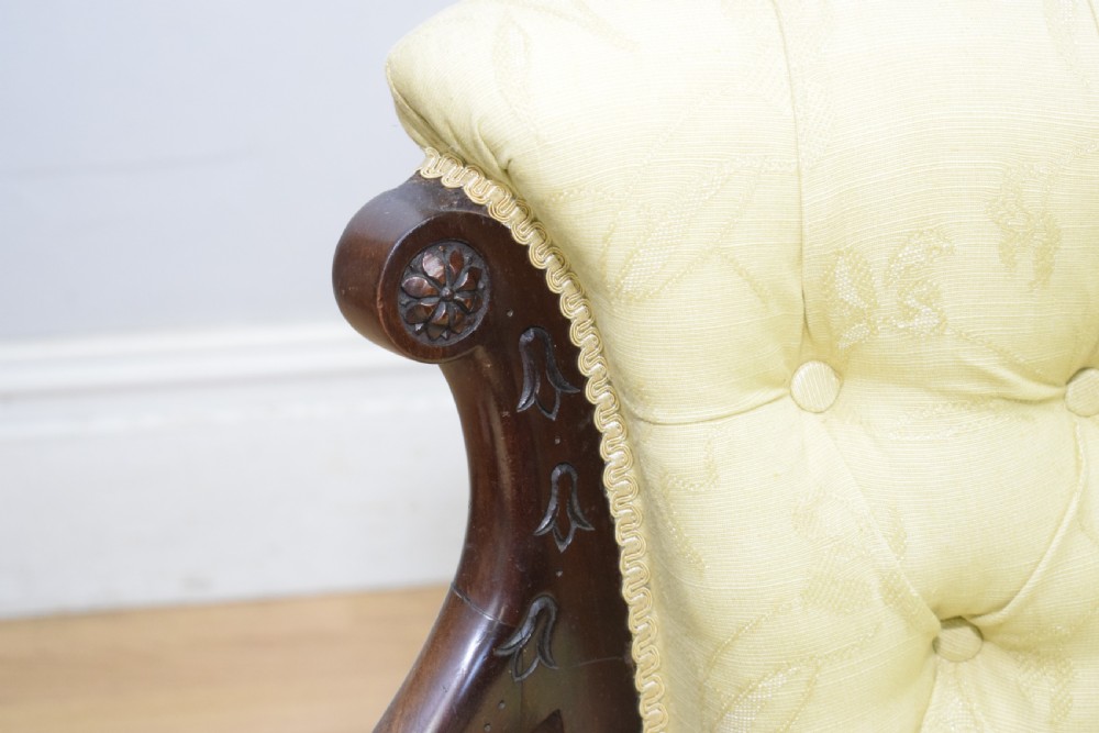 A Victorian mahogany settee featuring yellow tufted upholstery, open spindled arms, carved legs, and brass castors. View XVIII