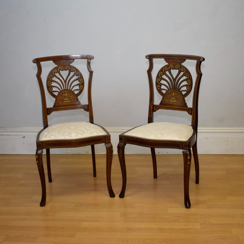 A pair of Victorian side chairs featuring dark mahogany frames with detailed marquetry inlays, fan-shaped pierced backrests, and cream upholstered seats. View III