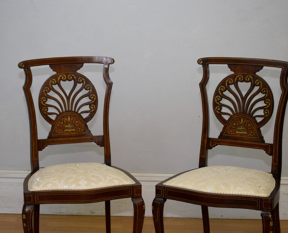 A pair of Victorian side chairs featuring dark mahogany frames with detailed marquetry inlays, fan-shaped pierced backrests, and cream upholstered seats. View VII