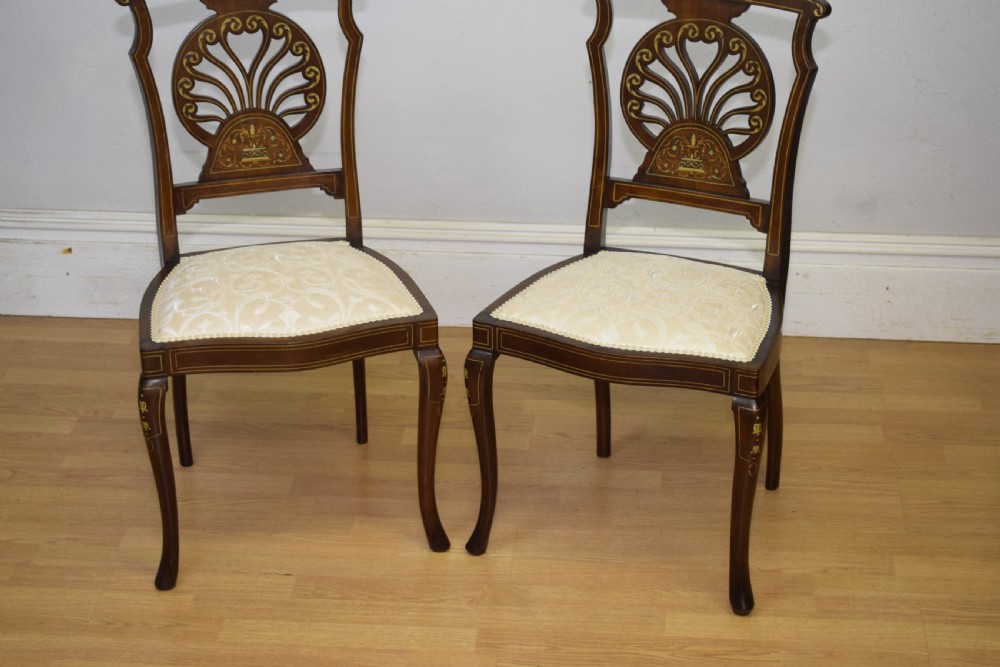 A pair of Victorian side chairs featuring dark mahogany frames with detailed marquetry inlays, fan-shaped pierced backrests, and cream upholstered seats. View X