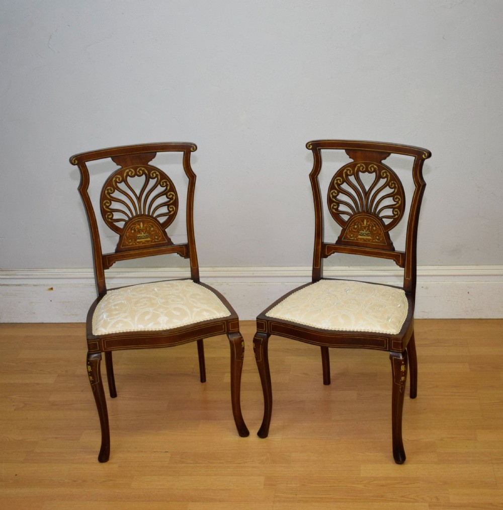 A pair of Victorian side chairs featuring dark mahogany frames with detailed marquetry inlays, fan-shaped pierced backrests, and cream upholstered seats. View XI
