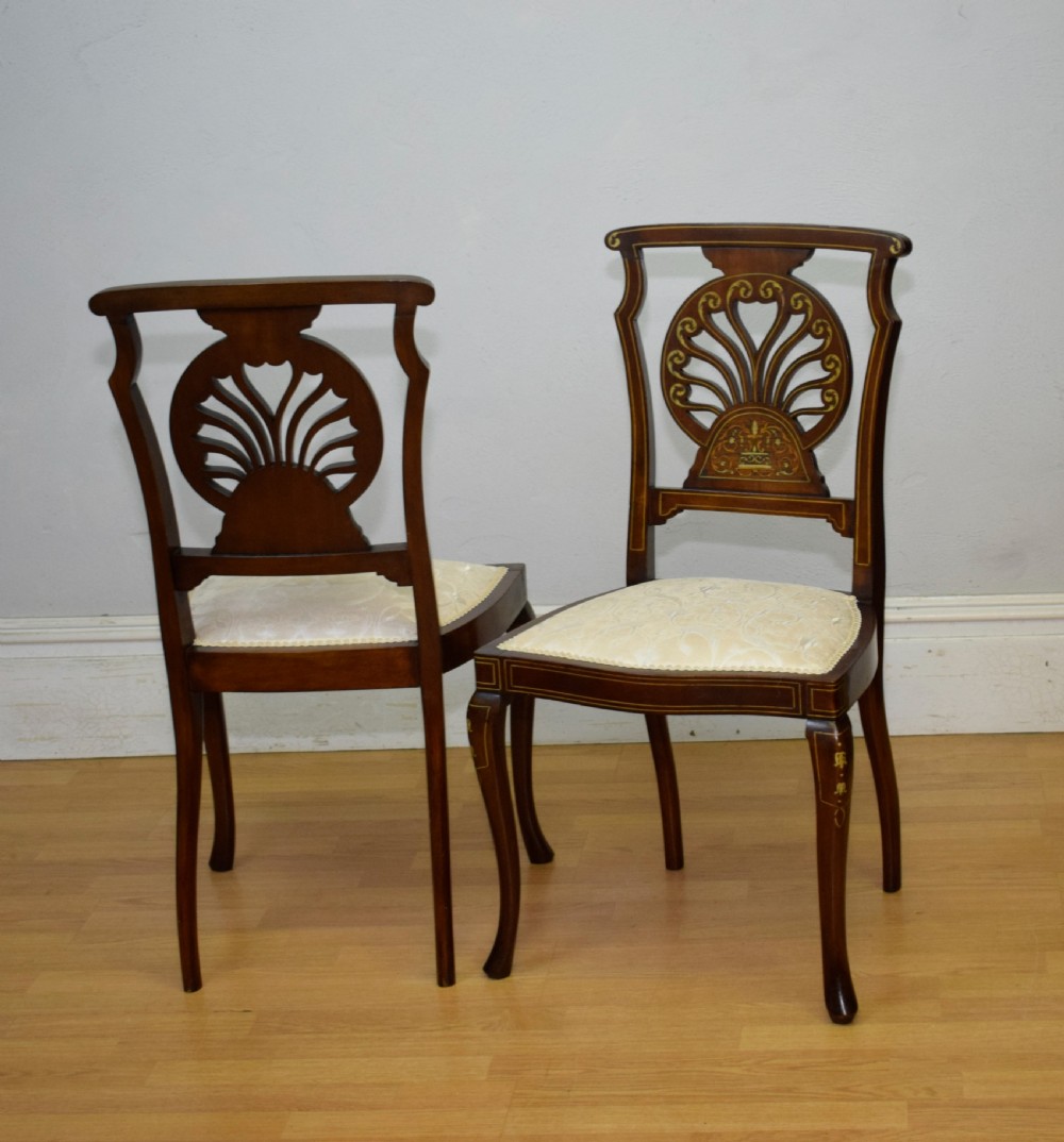 A pair of Victorian side chairs featuring dark mahogany frames with detailed marquetry inlays, fan-shaped pierced backrests, and cream upholstered seats. View XX