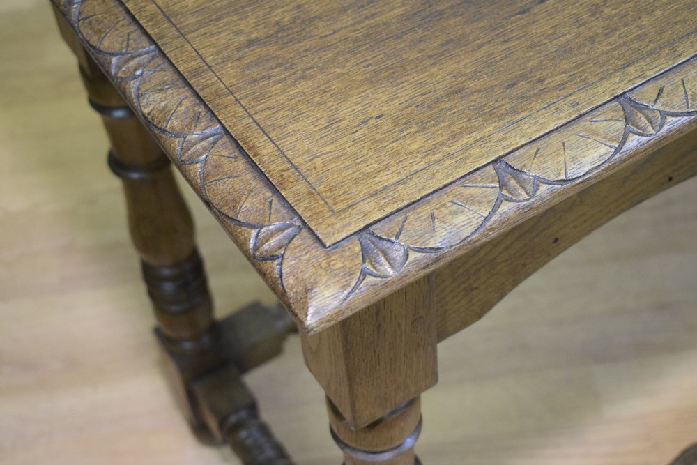 An early 20th-century oak console table featuring turned legs, a shaped apron, carved top edge, and low stretcher supports. View VIII