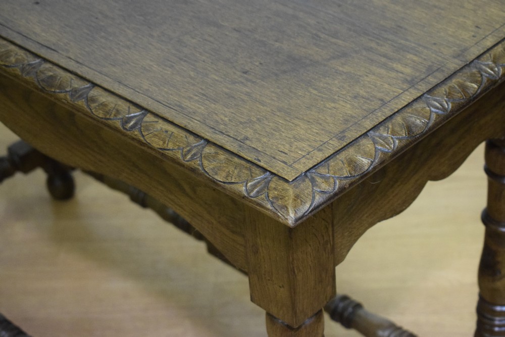 An early 20th-century oak console table featuring turned legs, a shaped apron, carved top edge, and low stretcher supports. View XIII