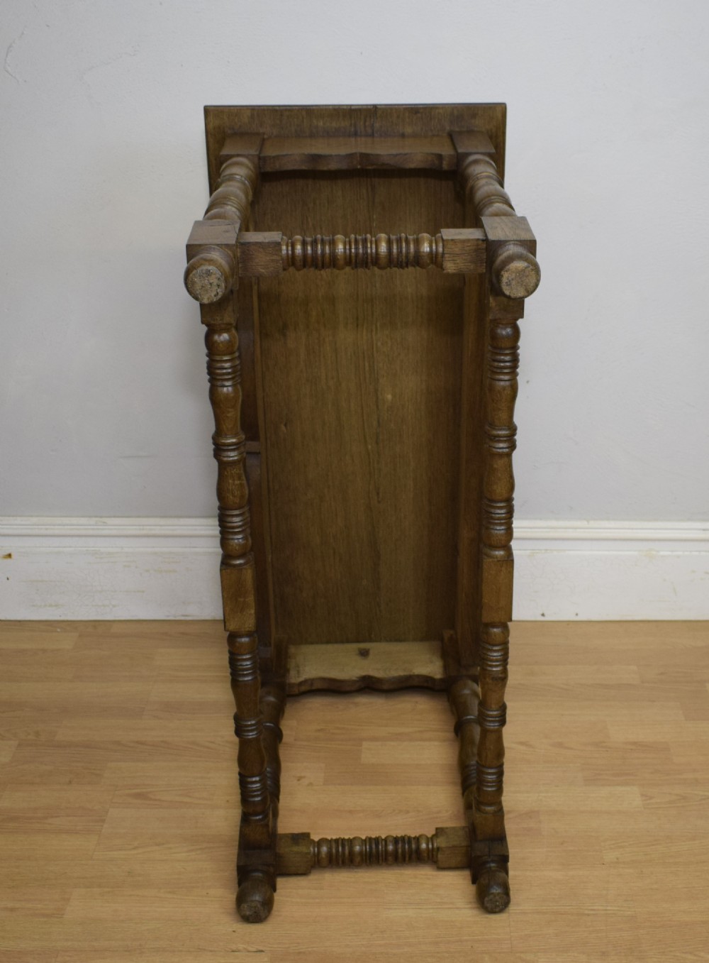 An early 20th-century oak console table featuring turned legs, a shaped apron, carved top edge, and low stretcher supports. View XIV