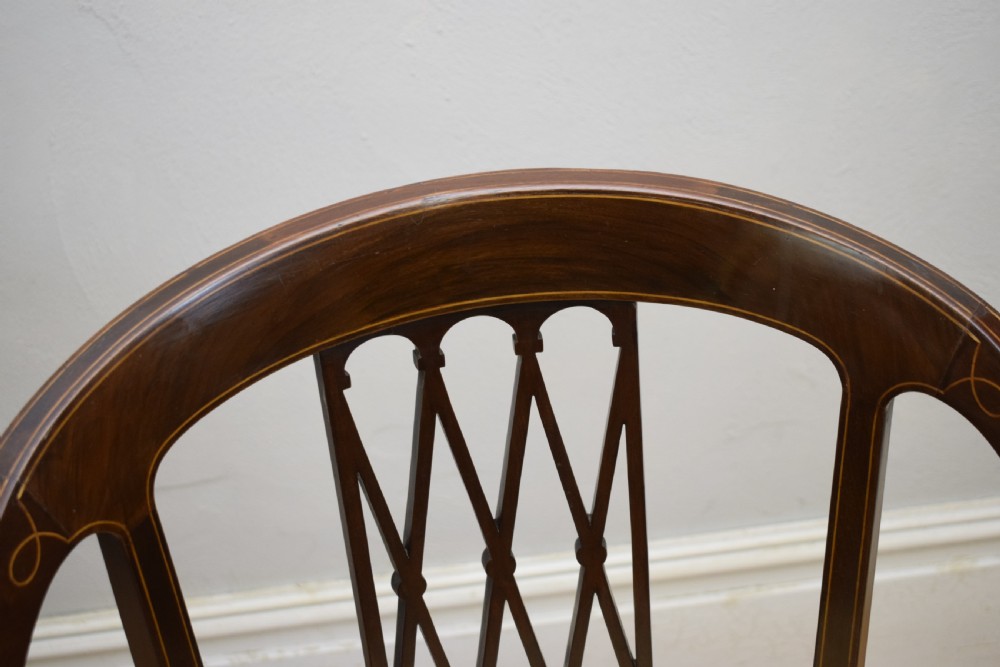 An Edwardian dark mahogany tub armchair featuring boxwood stringing inlay, pierced lattice back panels, and a yellow patterned upholstered seat. View IX