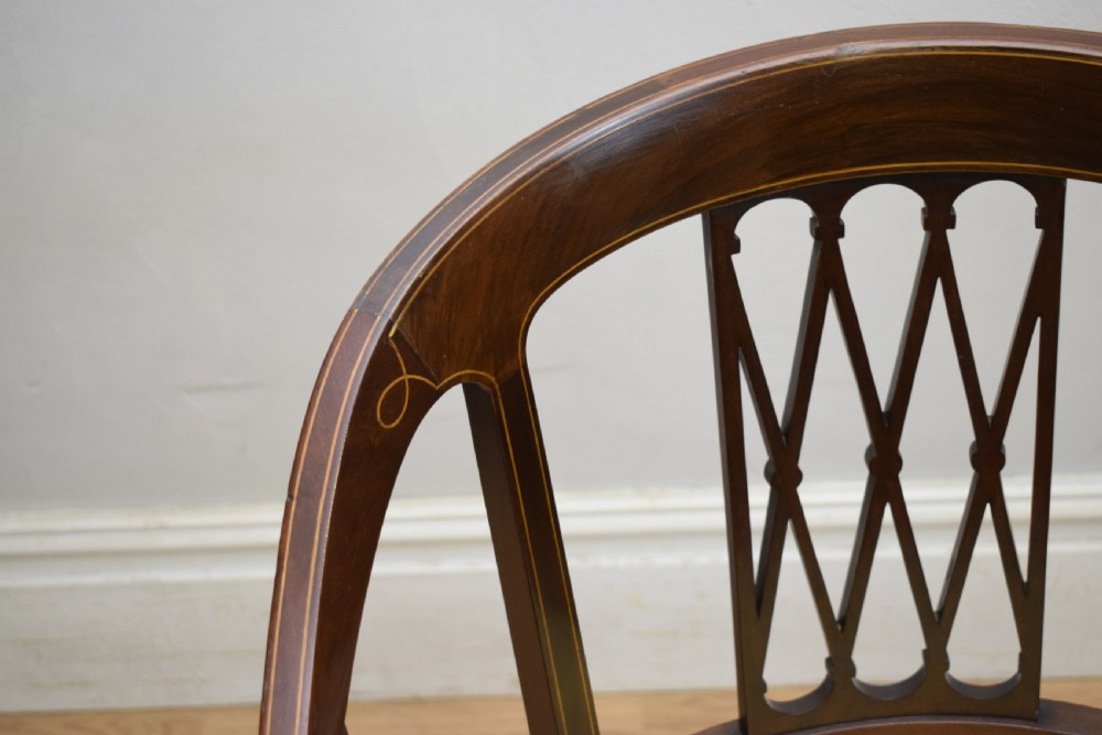 An Edwardian dark mahogany tub armchair featuring boxwood stringing inlay, pierced lattice back panels, and a yellow patterned upholstered seat. View XII