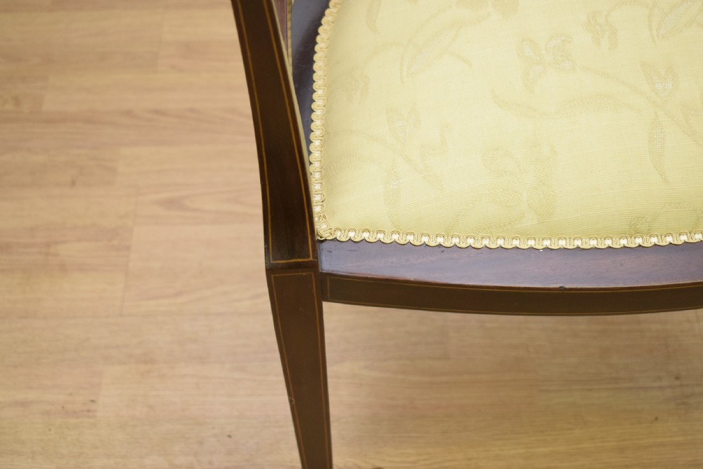 An Edwardian dark mahogany tub armchair featuring boxwood stringing inlay, pierced lattice back panels, and a yellow patterned upholstered seat. View XIII