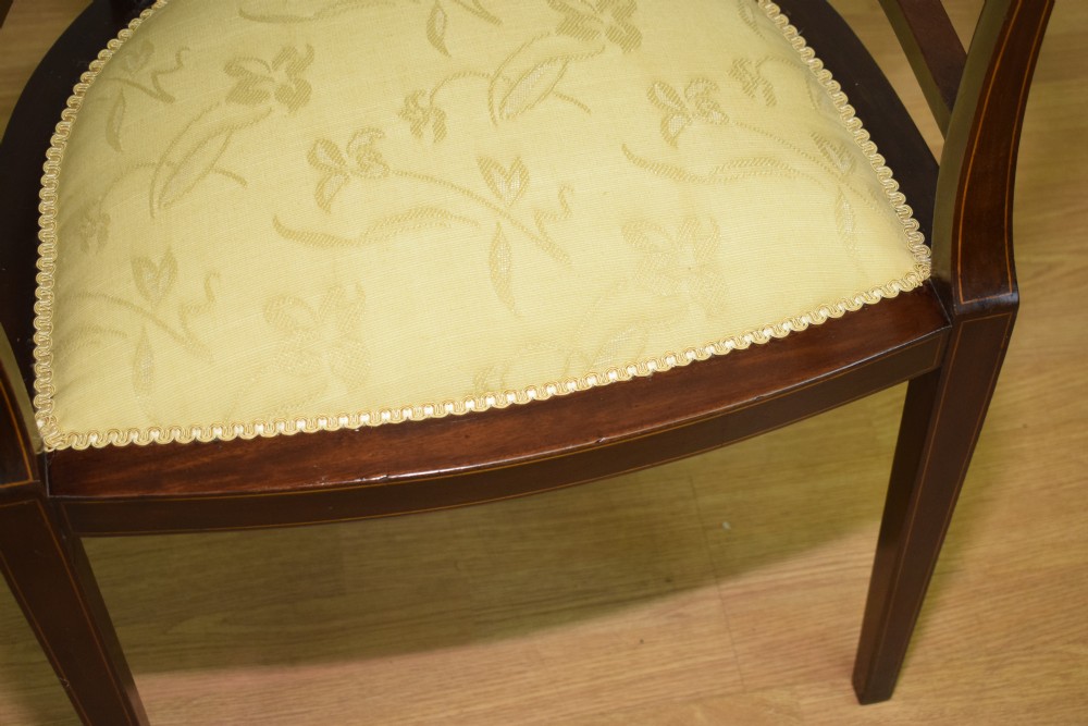 An Edwardian dark mahogany tub armchair featuring boxwood stringing inlay, pierced lattice back panels, and a yellow patterned upholstered seat. View XIV