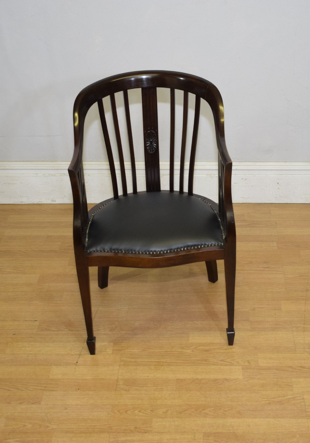 A Victorian dark mahogany tub chair featuring a curved backrest with vertical splats, a central carved oval patera, and a black leather studded seat. View III