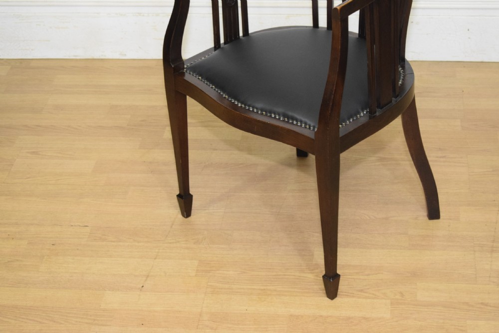 A Victorian dark mahogany tub chair featuring a curved backrest with vertical splats, a central carved oval patera, and a black leather studded seat. View V