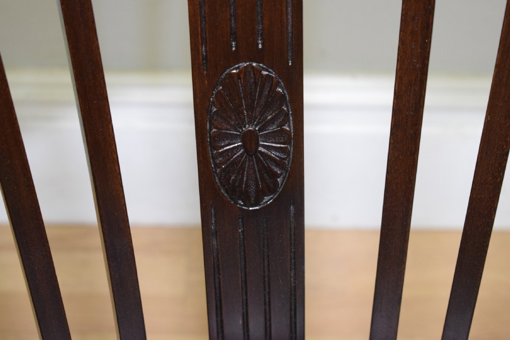 A Victorian dark mahogany tub chair featuring a curved backrest with vertical splats, a central carved oval patera, and a black leather studded seat. View VIII