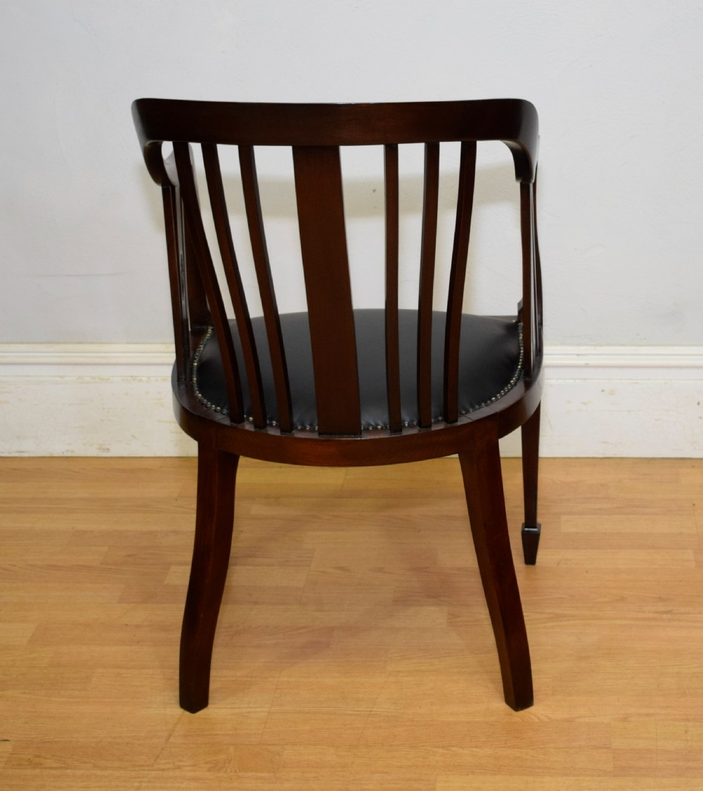 A Victorian dark mahogany tub chair featuring a curved backrest with vertical splats, a central carved oval patera, and a black leather studded seat. View XI