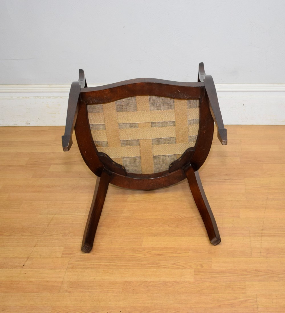 A Victorian dark mahogany tub chair featuring a curved backrest with vertical splats, a central carved oval patera, and a black leather studded seat. View XII