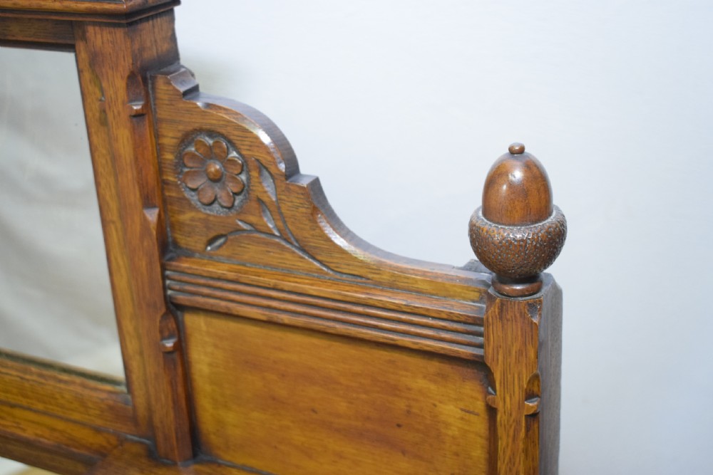 A Victorian carved oak overmantel mirror featuring turned side columns, small side display shelves, an arched pediment, and mirrored glass panels. View XXII