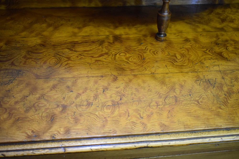 A Victorian golden pine dresser base featuring six drawers, a central panelled cupboard door, brass handles, and a shaped gallery back with a small shelf. View XX