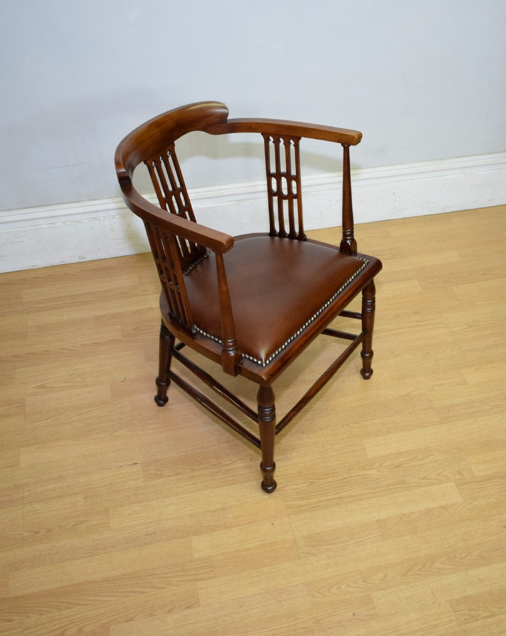 A Victorian dark mahogany tub armchair featuring a curved backrest with pierced vertical splats and a brown leather padded seat secured with brass studs. View XIII