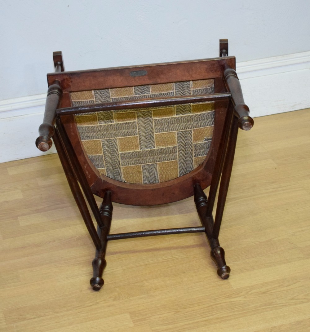 A Victorian dark mahogany tub armchair featuring a curved backrest with pierced vertical splats and a brown leather padded seat secured with brass studs. View XVII