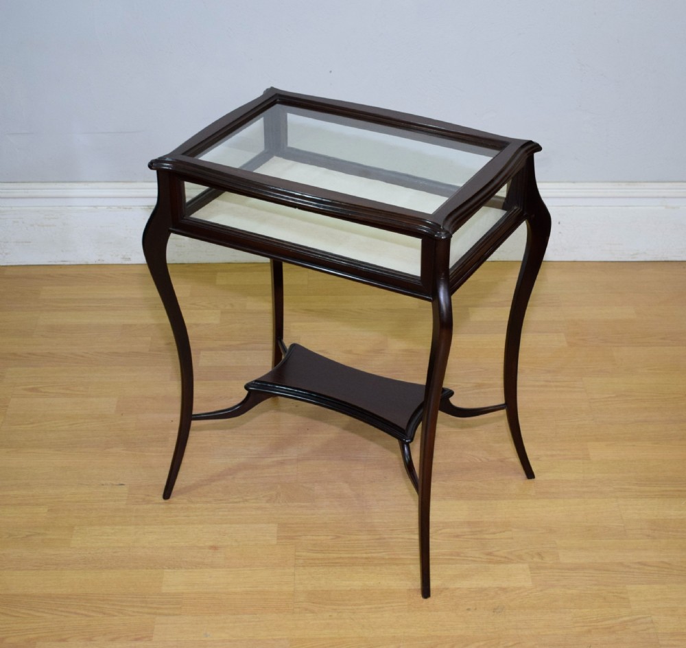 A Victorian dark mahogany bijouterie display table featuring four cabriole legs, clear glass side panels, a hinged glazed top, and a lower curved shelf. View II