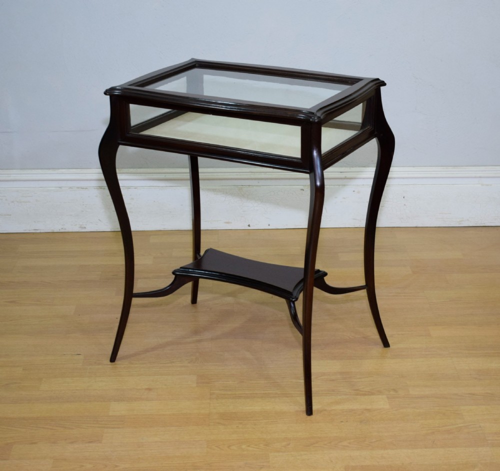 A Victorian dark mahogany bijouterie display table featuring four cabriole legs, clear glass side panels, a hinged glazed top, and a lower curved shelf. View III