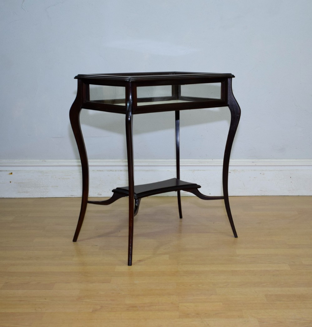 A Victorian dark mahogany bijouterie display table featuring four cabriole legs, clear glass side panels, a hinged glazed top, and a lower curved shelf. View XIII