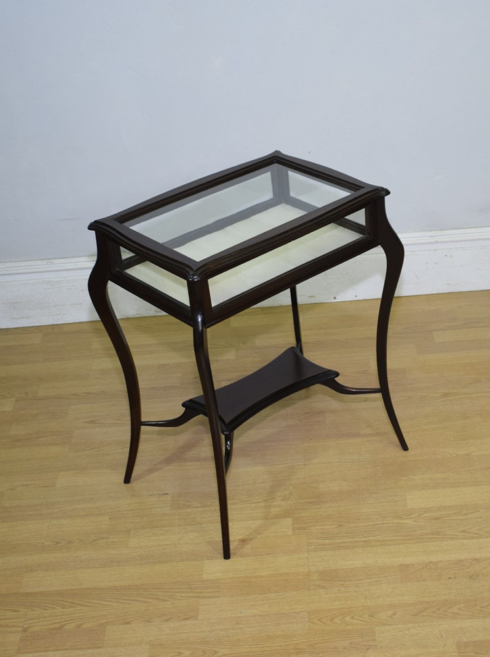 A Victorian dark mahogany bijouterie display table featuring four cabriole legs, clear glass side panels, a hinged glazed top, and a lower curved shelf. View XIV