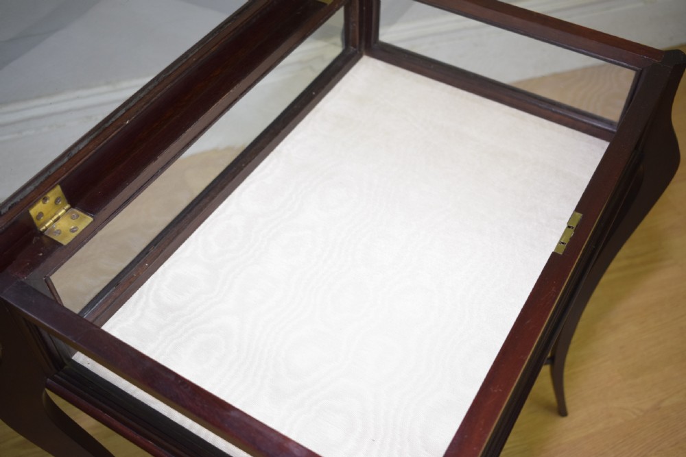 A Victorian dark mahogany bijouterie display table featuring four cabriole legs, clear glass side panels, a hinged glazed top, and a lower curved shelf. View XVIII