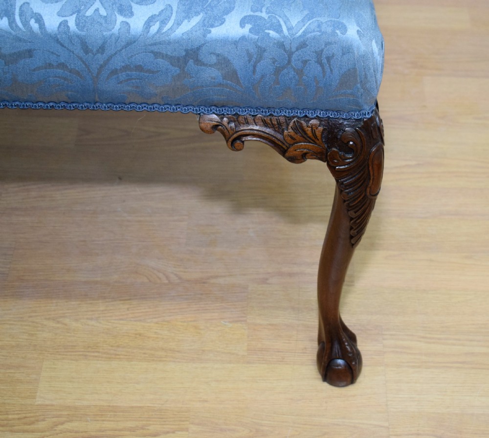 An early 20th-century mahogany triple chair-back Chippendale style settee featuring carved pierced back splats, light blue patterned upholstery, and cabriole legs with ball-and-claw feet. View XI