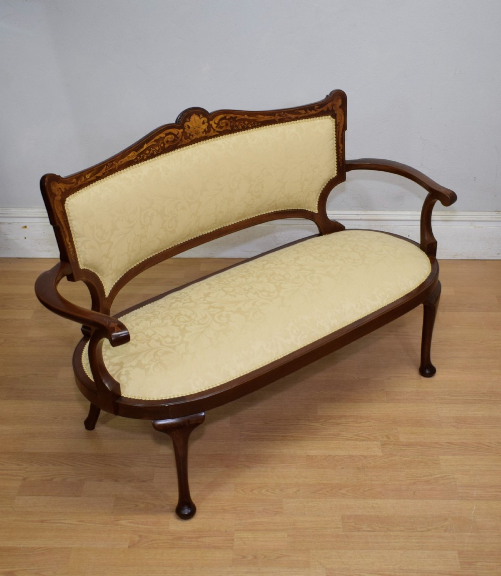 A Victorian dark mahogany settee with floral marquetry inlay along the crest rail and cream damask upholstered seat and backrest. View III