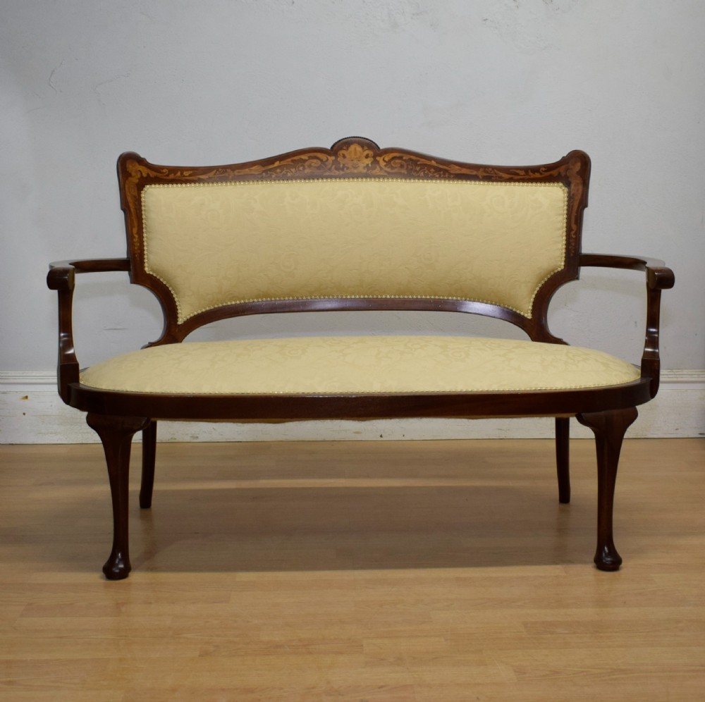 A Victorian dark mahogany settee with floral marquetry inlay along the crest rail and cream damask upholstered seat and backrest. View VII
