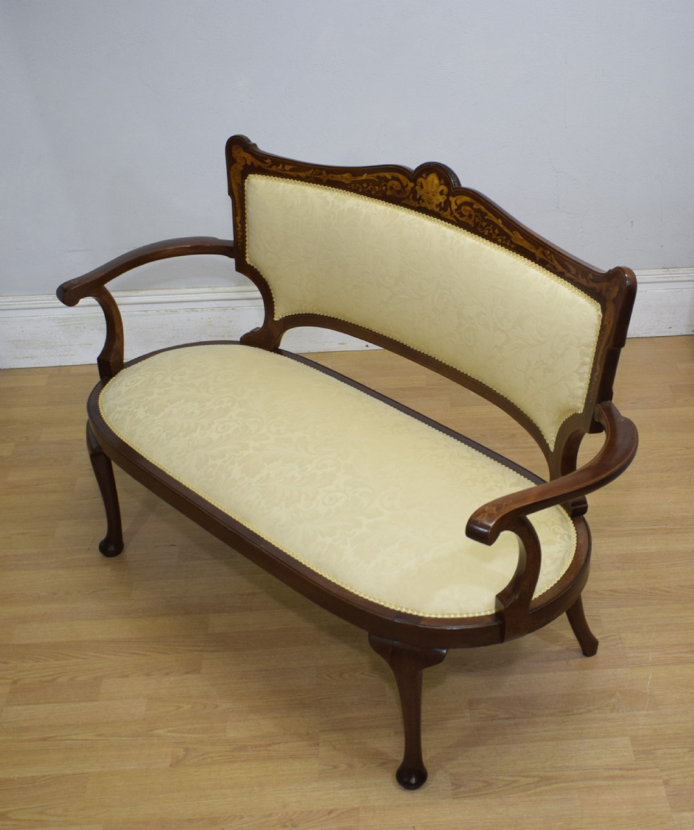 A Victorian dark mahogany settee with floral marquetry inlay along the crest rail and cream damask upholstered seat and backrest. View VIII
