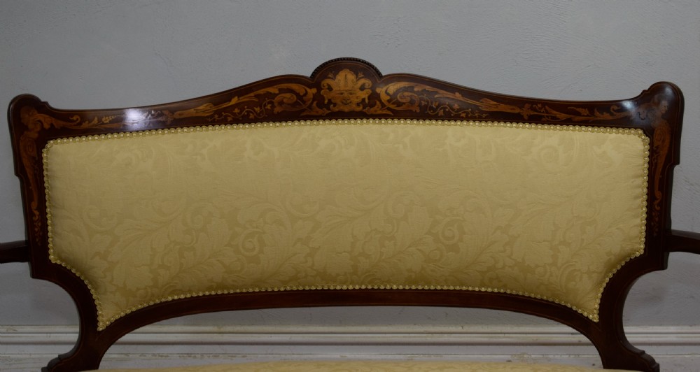 A Victorian dark mahogany settee with floral marquetry inlay along the crest rail and cream damask upholstered seat and backrest. View IX