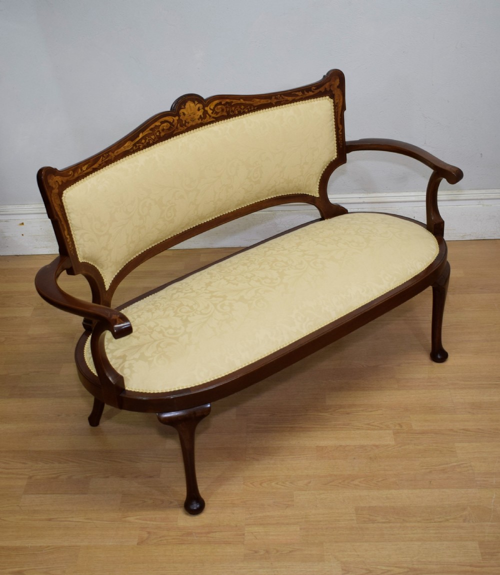 A Victorian dark mahogany settee with floral marquetry inlay along the crest rail and cream damask upholstered seat and backrest. View XIV