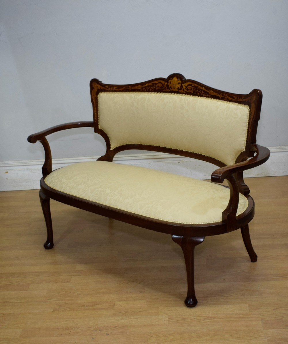 A Victorian dark mahogany settee with floral marquetry inlay along the crest rail and cream damask upholstered seat and backrest. View XV
