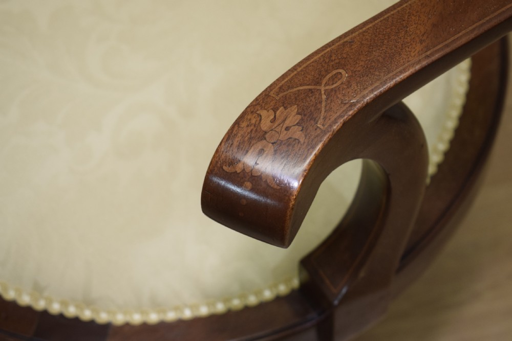 A Victorian dark mahogany settee with floral marquetry inlay along the crest rail and cream damask upholstered seat and backrest. View XVI